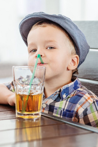 快乐的小男孩喝果汁的肖像