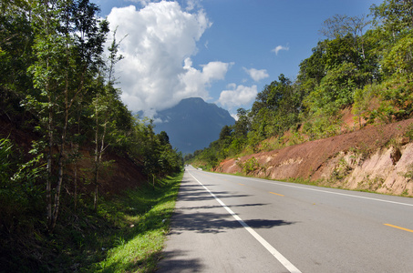 泰国清迈市的树木道路山和多云的蓝天