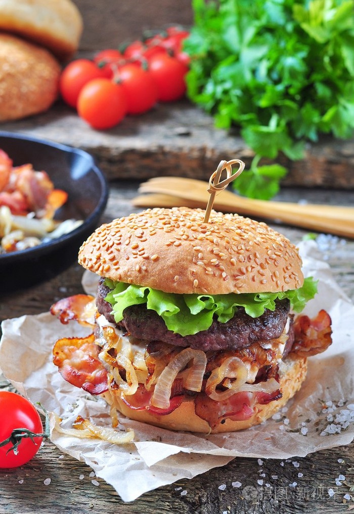 多汁的自制双人汉堡牛肉和炸洋葱在木制的