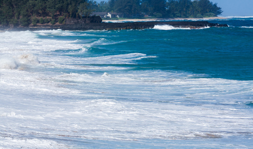 强大的海浪流经岩石在鲁玛海海滩，考艾岛