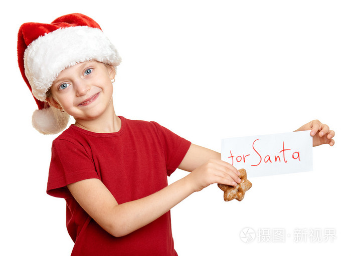 在圣诞老人的帽子与饼干冬天的节日圣诞节概念中的女孩