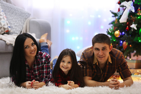 幸福的家庭，在装饰圣诞房间的地板上