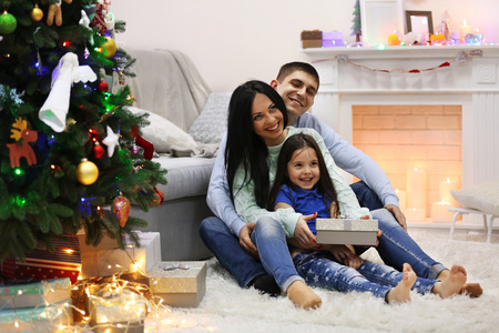 幸福的家庭，与礼品装饰圣诞房间里地板上