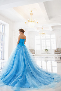 美丽的新娘在华丽的蓝色连衣裙灰姑娘风格在一个早晨