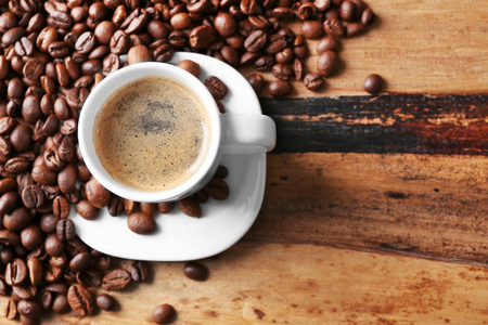 杯咖啡和咖啡粒木制表背景