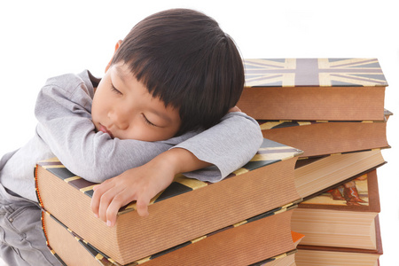 亚洲的可爱男孩，睡在一摞书上