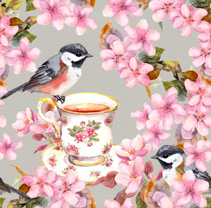 带漂亮鸟的茶杯在盛开的粉红色花园里。 水