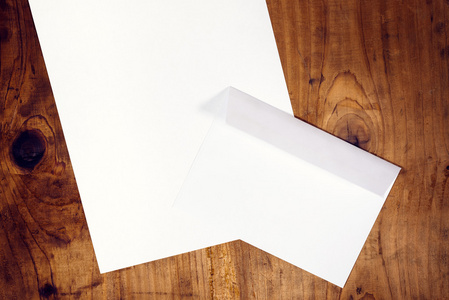 空白的白色信封和纸木桌子上