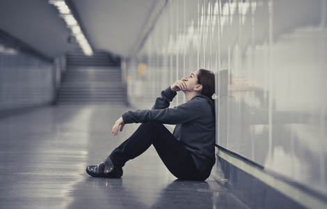 年轻悲伤的女人独自痛苦和沮丧在城市地铁隧道照片