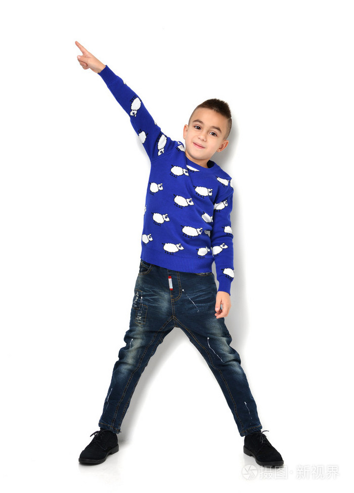 穿着蓝布牛仔裤的小男孩站着,手指着t