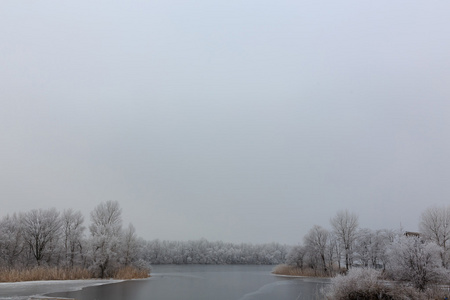 寒冷的天气。冬季在村里。湖面上的冰