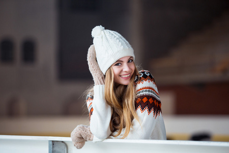 年轻女人穿着件温暖的羊毛开衫 手套和帽子在滑冰公园构成外