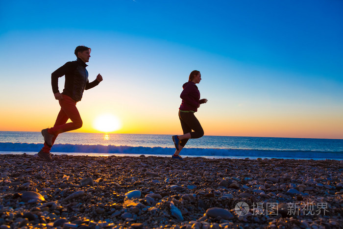 运动对夫妇,日出时分做早晨慢跑上海滩