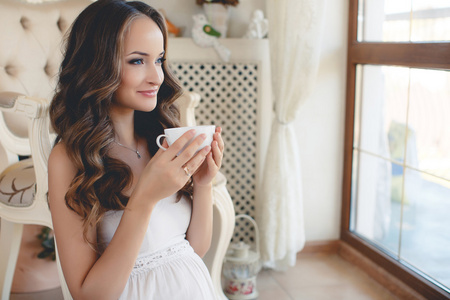 年轻的孕妇与一杯茶