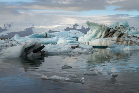 冰块在 Jokulsarlon 冰川泻湖与雪山背景