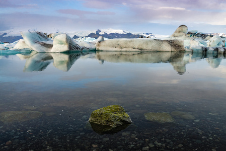 冰块与在 Jokulsarlon 冰川泻湖冰岛青苔岩石前景的思考