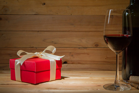庆祝与木制背上的礼品盒，葡萄酒玻璃的概念