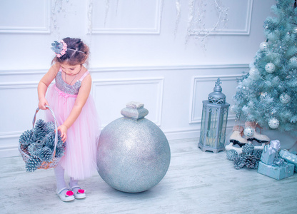 小女孩穿着美丽时尚白色花连衣裙附近圣诞树摆姿势