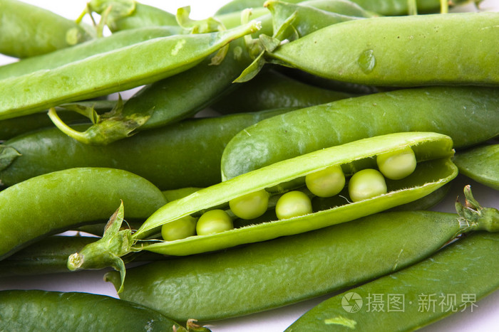 豌豆新鲜的绿色豌豆荚和种子上白色孤立鲜绿色豌豆在心的形状新鲜的
