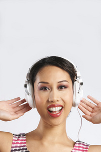 女人听音乐通过耳机的影棚拍摄