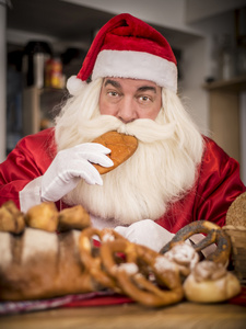 圣诞老人在厨房里对待美味面包