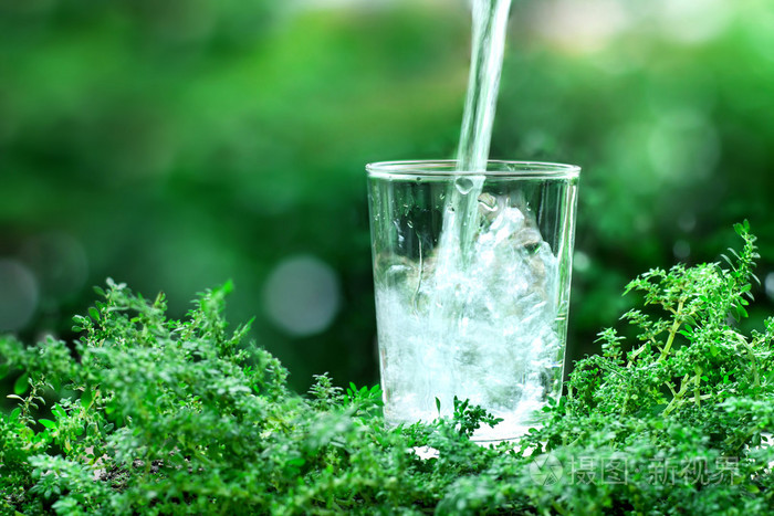一杯清凉新鲜水天然绿色背景