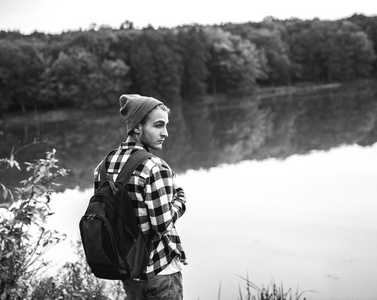 年轻男子站独自户外旅行的生活方式概念与湖