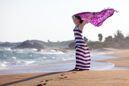 女人站在海边和波与她的披肩