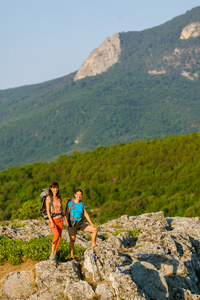 两名妇女在克里米亚山脉背着背包徒步旅行