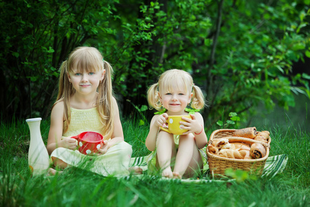 女孩在与牛奶和面包湖野餐