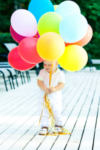 白种人宝贝男孩扮演着气球在公园