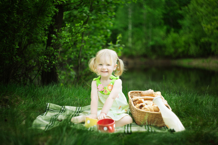 女孩在与牛奶和面包湖野餐