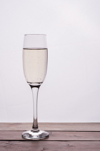 在白色背景下的木桌上的香槟杯