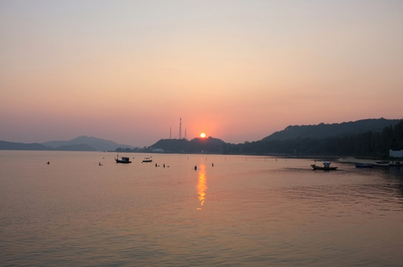 日落下海滩码头的海洋和山脉图片