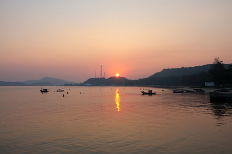 日落下海滩码头的海洋和山脉图片