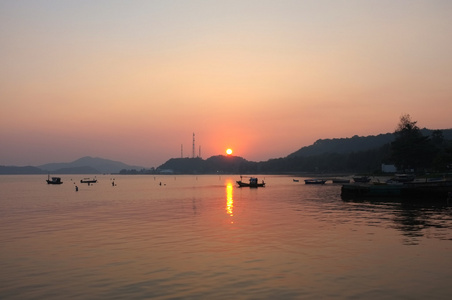 日落下海滩码头的海洋和山脉图片