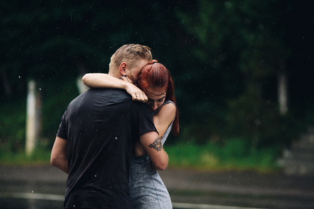 美丽的夫妇在雨中拥抱