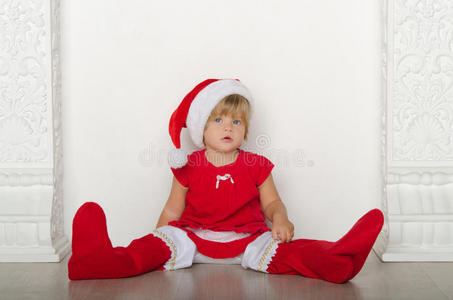 穿着圣诞老人服装的女孩坐在地板上