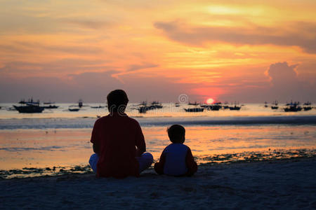 父子俩在海滩上看日落