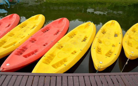 在水边划出一排黄色和粉红色的独木舟皮划艇。