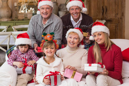 一个幸福的大家庭的肖像，戴着圣诞帽拿着礼物