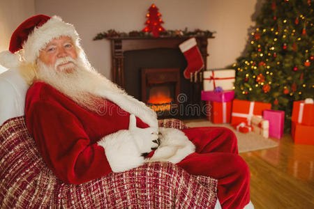 微笑的圣诞老人坐着抱着他的肚子