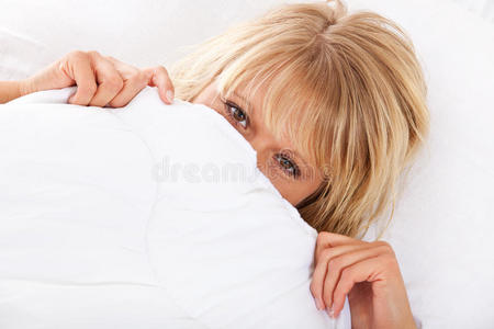 女人把脸藏在床单下面