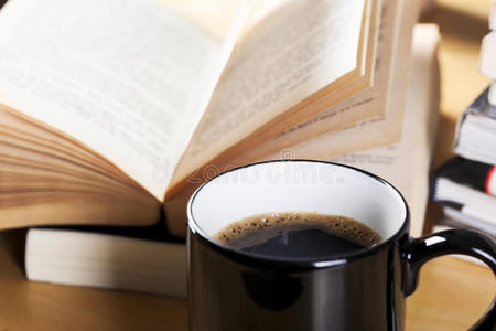 黑杯咖啡和打开的书堆