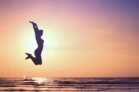 在海上夕阳中跳跃的女孩