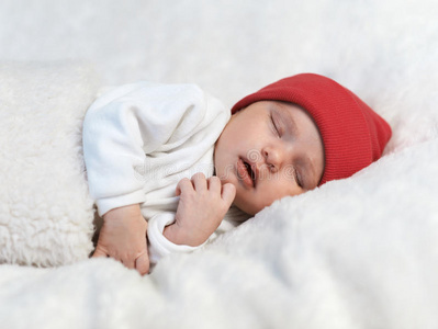 婴儿睡在白色的红帽子里