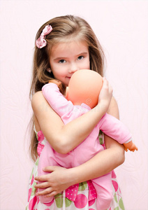 可爱的小女孩抱着她的洋娃娃