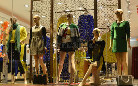 晚上5个冬季时装模特在服装店橱窗里照片