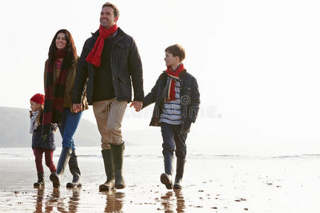 一家人沿着冬天的海滩散步