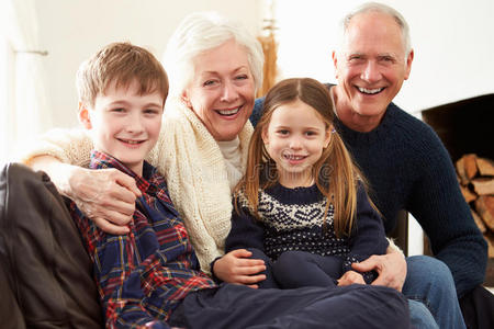 祖父母和孙子孙女坐在沙发上的肖像